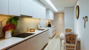 a kitchen with white cabinets and a counter top at Agrinho Suites & Spa Gerês in Valdosende