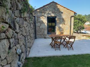 una mesa y sillas frente a un edificio de piedra en River House Sejães, en Oliveira de Frades 20 fotos más