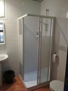 a shower with a glass door in a bathroom at galerna aterpetxea in Zarautz