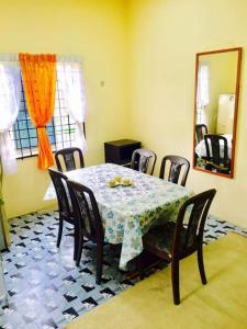 comedor con mesa, sillas y espejo en Homestay Bandar Pekan - musleem preferred, en Pekan