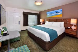 a hotel room with a large bed and a desk at Old Town Inn in San Diego +37 photos