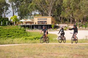 
two men riding bikes down a street next to a forest at Birdwood Motel in Birdwood
