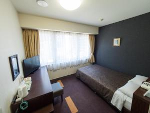 Un ou plusieurs lits dans un hébergement de l'établissement Hotel Shin Osaka