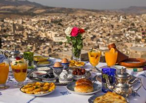 uma mesa com comida e bebidas e vista para a cidade em Dar Bab Jdid em Fez