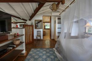 a bedroom with a bed and a living room at Casas da Lia in Trancoso