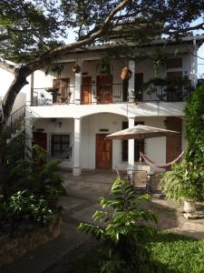 a white house with a porch and a patio at Jardín Café Hotel & Restaurant in Gracias