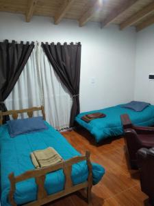 1 dormitorio con 2 camas y 1 silla en Corazon De Mendoza en San Rafael