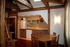 a kitchen with a wooden table and a refrigerator at Goldingen in Kuldīga