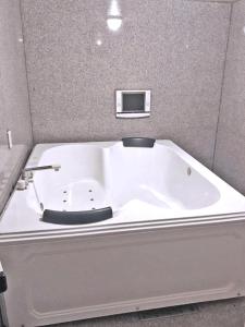 La salle de bains est pourvue d'une grande baignoire blanche. dans l'établissement Hotel Pal Anesso Nakatsu (Love Hotel), à Nakatsu