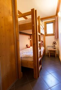 a bedroom with two bunk beds in a room at Résidence Le Critérium in Lanslebourg-Mont-Cenis