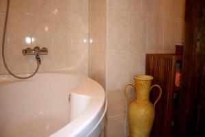 a bathroom with a tub and a vase next to it at Goldingen in Kuldīga