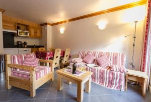 a living room with two couches and a table at Résidence Le Critérium in Lanslebourg-Mont-Cenis