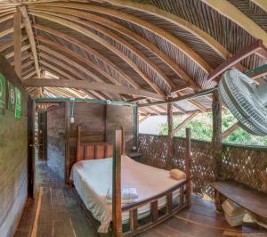 パロミノにあるHostal La Media Luna Palominoの木製の天井の客室のベッド1台分です。
