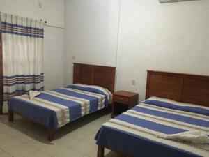 a room with two beds in a room at Hotel De Santiago in Chiapa de Corzo