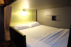 曼谷的住宿－四姐妹民宿，一间小卧室,配有一张白色的床和灯