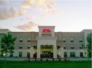 un gran edificio con una señal roja delante de él en Hampton Inn & Suites Dumas, en Dumas