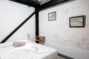 Habitación con cama y pared blanca en Medellin Backpacker Hostel, en Medellín