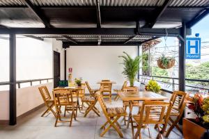 Un restaurante vacío con mesas y sillas de madera. en Medellin Backpacker Hostel, en Medellín