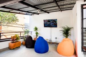 Una sala de estar con muebles azules y naranjas y un balcón. en Medellin Backpacker Hostel, en Medellín