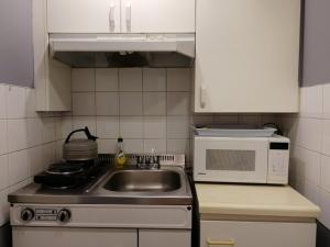 a kitchen with a sink and a microwave at Motel Chantolac in Sainte-Adèle