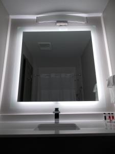 a mirror over a sink in a bathroom at Super 8 by Wyndham Santa Cruz Beach Boardwalk in Santa Cruz +19 photos