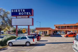 un panneau pour une siesta motel dans un parking dans l'établissement Siesta Motel, à Nogales