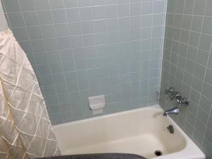 a bathroom with a bath tub with blue tiles at Sandy Shores Resort in North Wildwood