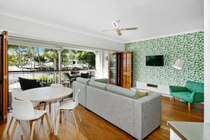 ein Wohnzimmer mit einem Sofa und einem Tisch in der Unterkunft Mantra on the Inlet in Port Douglas