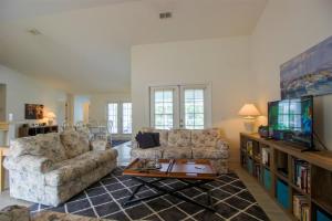 a living room with two couches and a tv at Luxury 2BR-3BA Pool Villa and 20 Min to WEC- Ocala in Inverness
