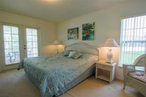 a bedroom with a bed and a chair and windows at Luxury 2BR-3BA Pool Villa and 20 Min to WEC- Ocala in Inverness +10 photos