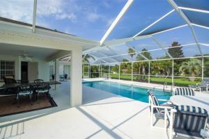 a patio with a table and chairs and a swimming pool at Luxury 2BR-3BA Pool Villa and 20 Min to WEC- Ocala in Inverness