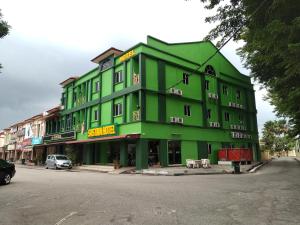 a green building on the side of a street at Sastria Hotel Sungai Petani in Sungai Petani