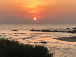 a sunset on the beach with the sun setting at C Beyond Nilaveli in Nilaveli