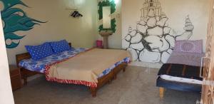 a bedroom with two beds and a painting on the wall at Padmaa Hampi Villa in Hampi