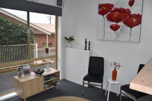 a room with two chairs and a table and a painting at Shannon Motor Inn in Geelong