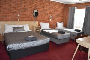 a hotel room with two beds and a couch at Shannon Motor Inn in Geelong