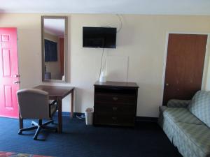 Pokój hotelowy z biurkiem, kanapą i krzesłem w obiekcie Encino Motel w mieście Pleasanton