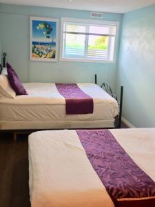 卡爾加里的住宿－卡爾加里明星舒適之家旅館，一间卧室设有两张床和窗户。