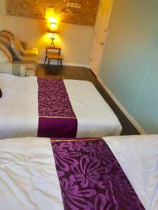 2 Betten in einem Zimmer mit lila und weißen Laken in der Unterkunft Calgary Star Cozy Home in Calgary
