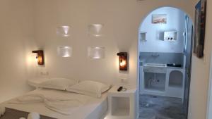 a small bedroom with a bed and a shower at Grey Rooms Naxos in Naxos Chora