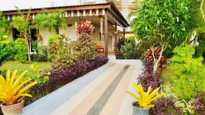 a garden with flowers and plants in front of a building at Siray House in Phuket