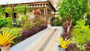 un jardín con flores y plantas frente a un edificio en Siray House, en Phuket