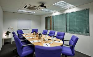una sala conferenze con tavolo e sedie viola di V Hotel Kuala Lumpur a Kuala Lumpur