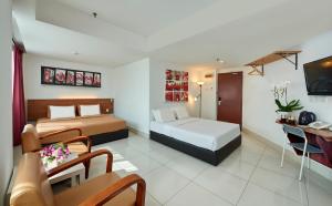 Habitación de hotel con 2 camas y escritorio en V Hotel Kuala Lumpur en Kuala Lumpur