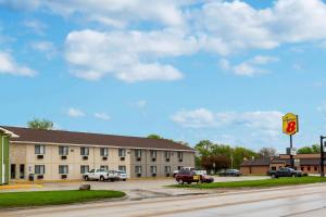 un edificio con coches estacionados en un estacionamiento en Super 8 by Wyndham Storm Lake, en Storm Lake