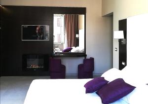 A bed or beds in a room at Roman Holidays Boutique Hotel