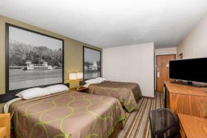 a hotel room with two beds and a flat screen tv at Super 8 by Wyndham Storm Lake in Storm Lake