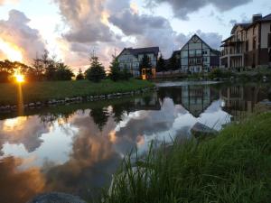 a view of a river at sunset with houses at Celinburg Guest House in Kaliningrad