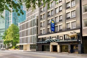 a building with a cow sign on the front of it at Days Inn by Wyndham Vancouver Downtown in Vancouver