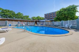 a swimming pool at a resort with tables and chairs at Days Inn & Suites by Wyndham Lebanon PA in Lebanon